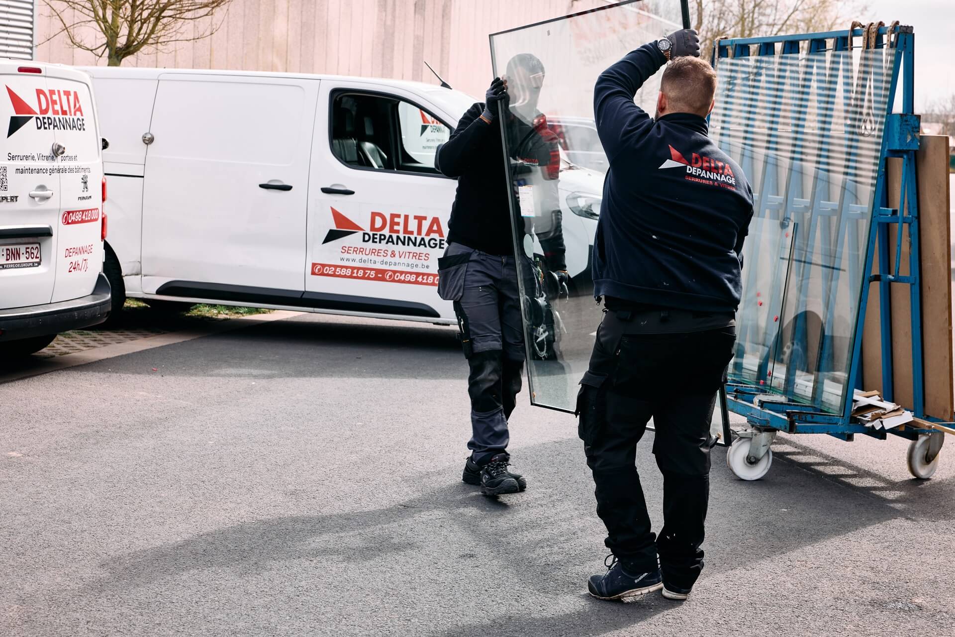 deux vitriers portant une vitre