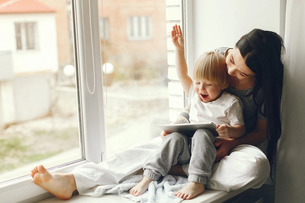 maman et enfant devant fenêtre blanche