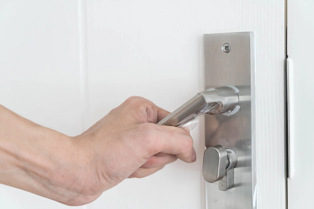 main baissant la poignée d'une porte