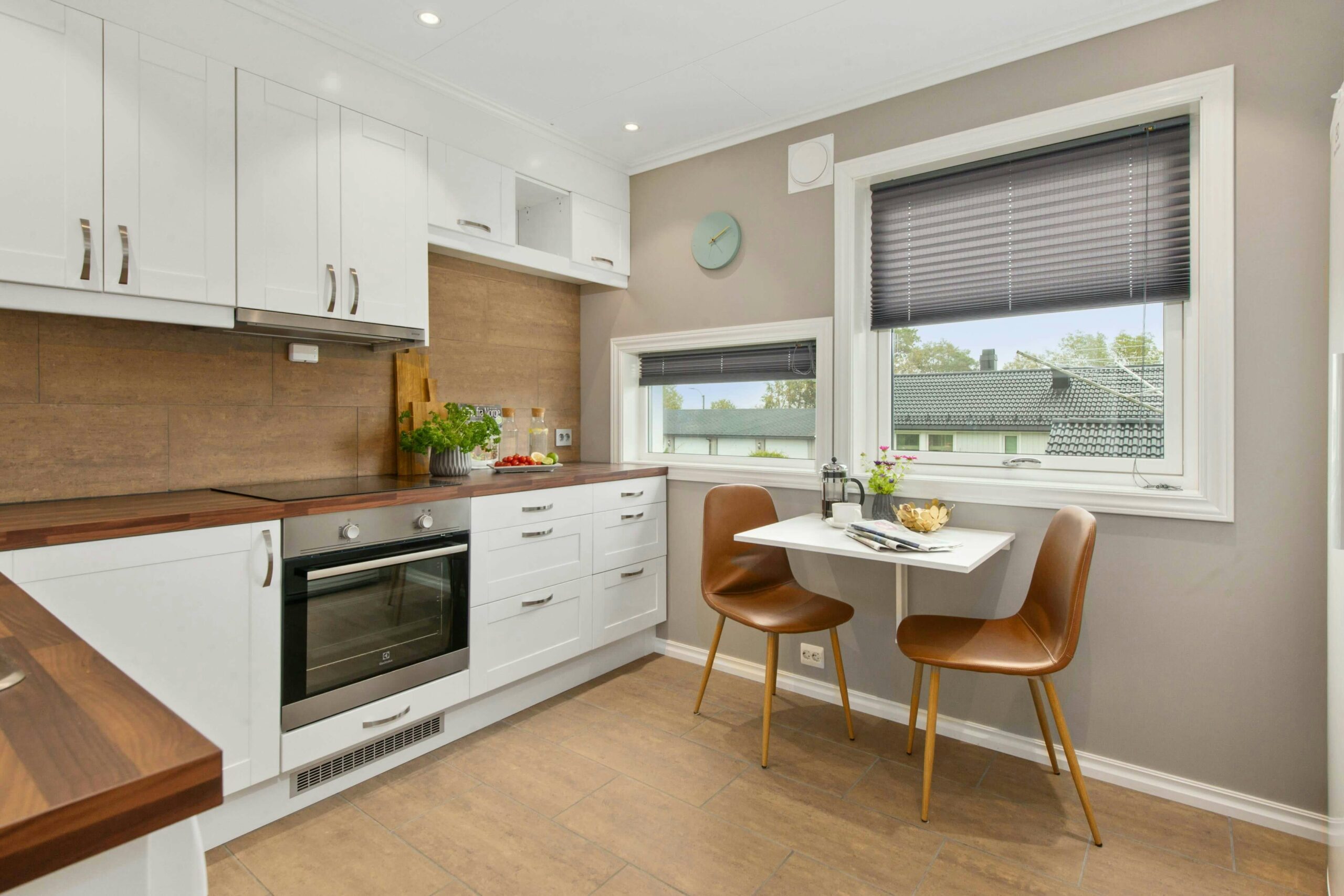 cuisine blanche avec vue sur le jardin à travers la fenêtre